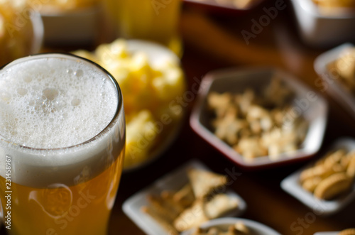 pint of lager beer in a glass, set of various snacks, a standard set of drinking and eating in a pub