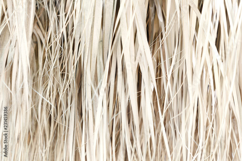 Old weathered coconut leaf roof of hut. Dried banana palm leaves background. Dried palm leaves texture. Close up organic gray palm leaves pattern background and texture. Abstract background.