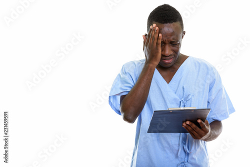 Studio shot of young black African man patient reading on clipbo photo