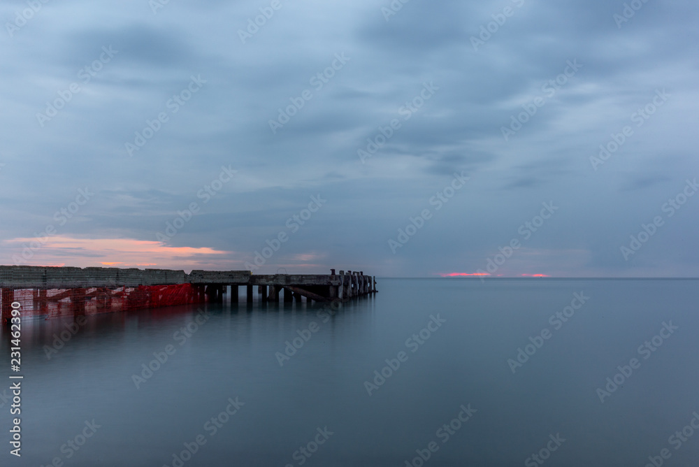 An abandoned pier on the Tuscan sea in Autumn at sunset with long exposure effect - 8