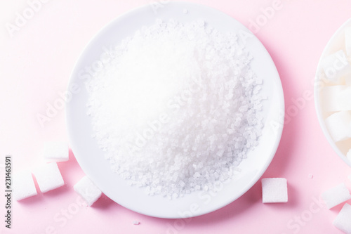 Sugar in crystaline sand, flat lay on pink background