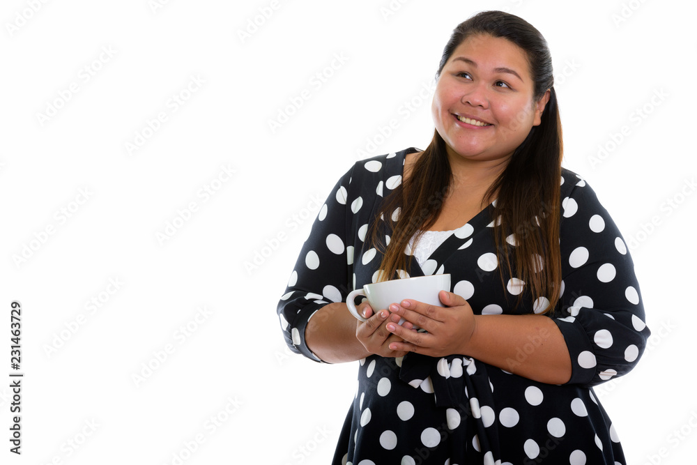 Studio shot of young happy fat Asian woman smiling and thinking Studio shot of young happy fat Asian woman smiling and thinking