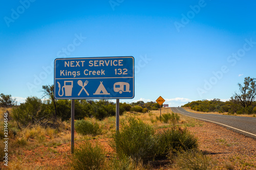 Road information sign reminding 162 km to next service station, Larapinta Drive, Northern Territory, Australia. Remoteness concept in Australian outback. photo