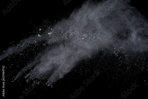 White powder explosion on black background. Dust splatted isolated. Paint Holi.