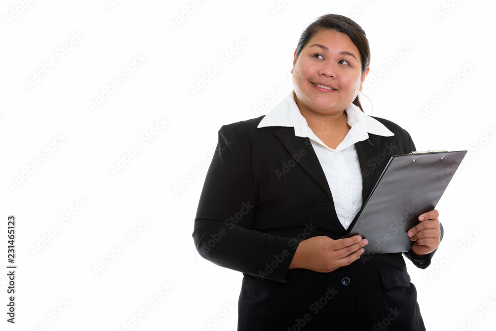 Thoughtful young happy fat Asian businesswoman smiling and looki Thoughtful young happy fat Asian businesswoman smiling and looki