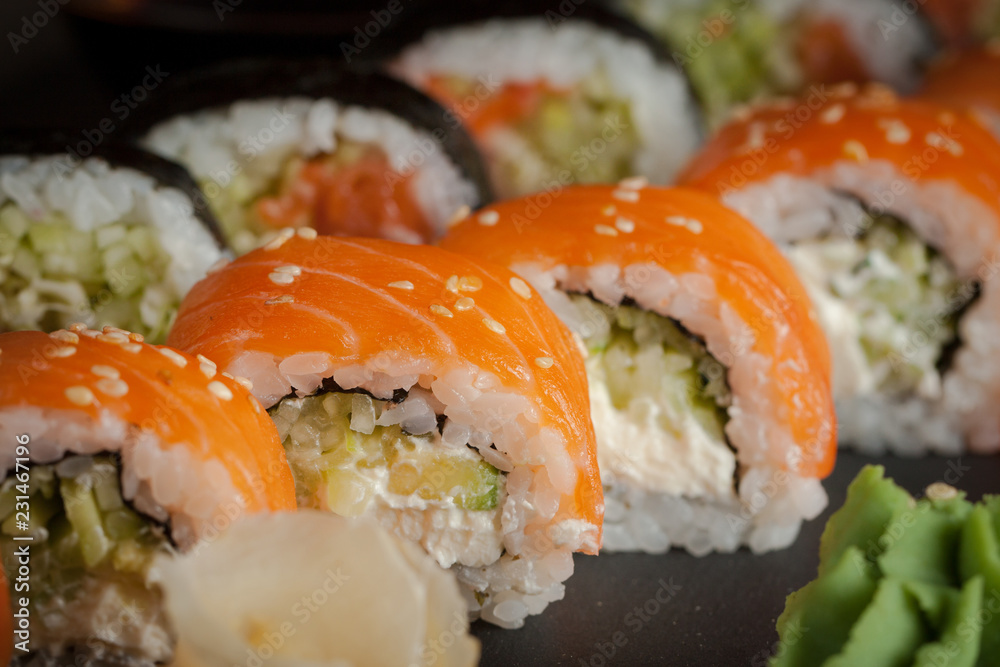 Maki rolls and nigiri sushi on a wooden table. Salmon, avocado and caviar rolls. Maki rolls and nigiri sushi on a wooden table. Salmon, avocado and caviar rolls.