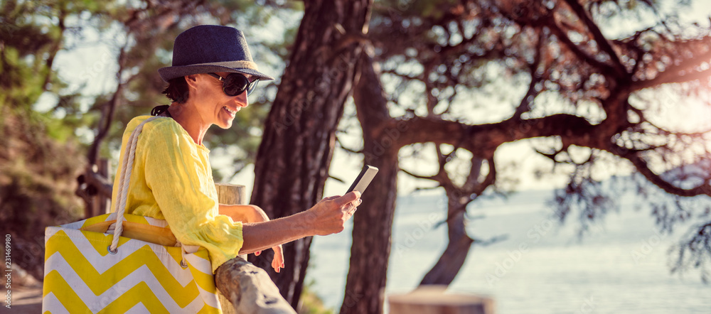 Woman standing at a wooden fence and using smart phone Woman standing at a wooden fence and using smart phone