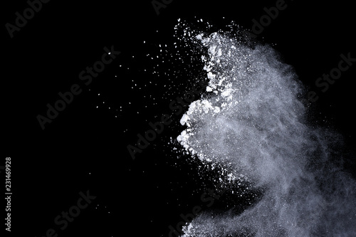White powder explosion on black background. Dust splatted isolated. Paint Holi.