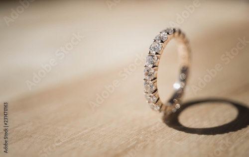 Close up of elegant diamond ring on wooden background. soft and selective focus. Love and wedding concept.