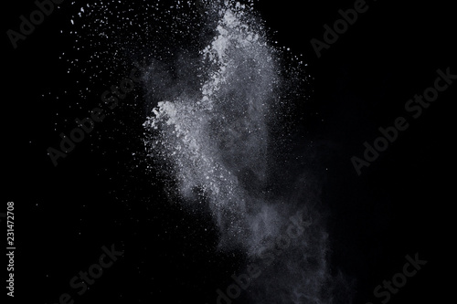 White powder explosion on black background. Dust splatted isolated. Paint Holi.