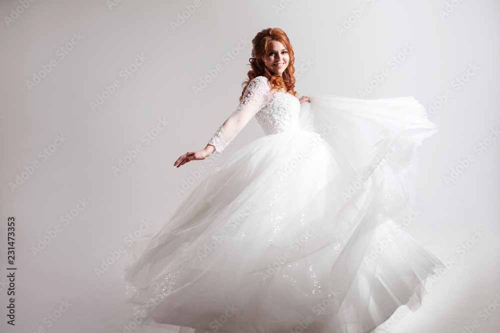 Lovely young woman bride in a lavish wedding dress. Light background. Lovely young woman bride in a lavish wedding dress. Light background.