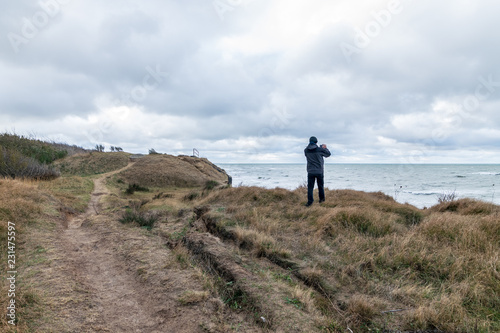 Mann fotografiert das Meer auf einer Steilküste