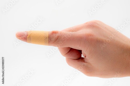 a hand with a patch on the forefinger, isolated against a white background