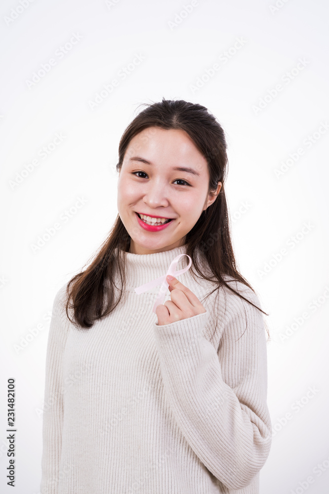 Breast Cancer concept. Pretty young woman holding pink breast cancer awareness ribbon 