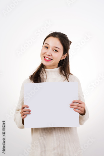 Young woman holding white board over white background