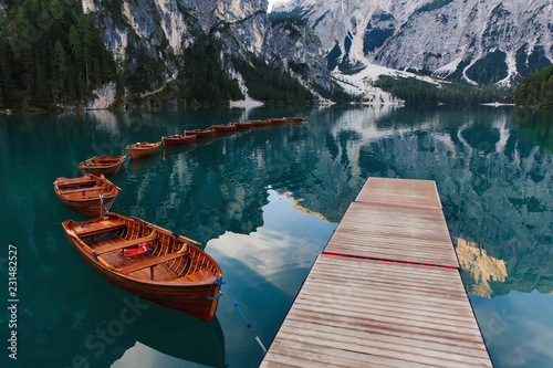 Beautiful landscape of Braies Lake (Lago di Braies), romantic place with wooden bridge and boats on the alpine lake, Alps Mountains, Dolomites, Italy, Europe