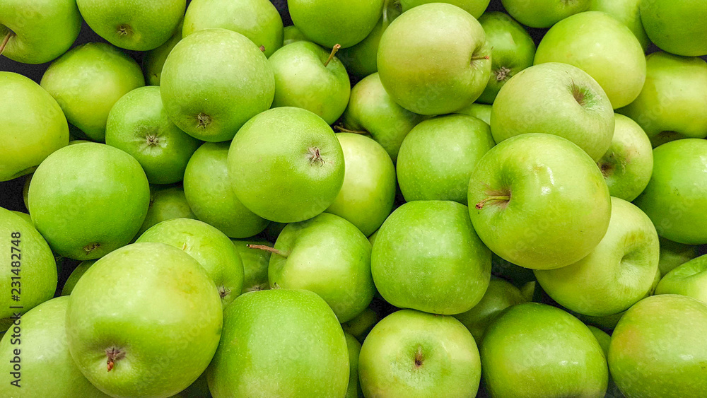background of many ripe and delicious green apples close-up background of many ripe and delicious green apples close-up