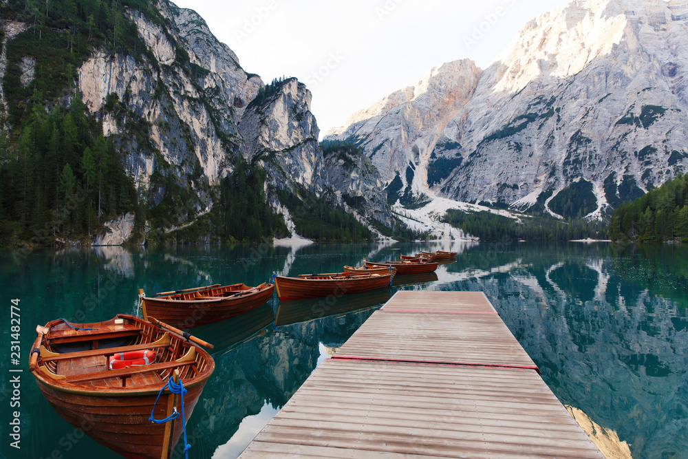 Fototapeta Beautiful landscape of Braies Lake (Lago di Braies), romantic place with wooden bridge and boats on the alpine lake, Alps Mountains, Dolomites, Italy, Europe