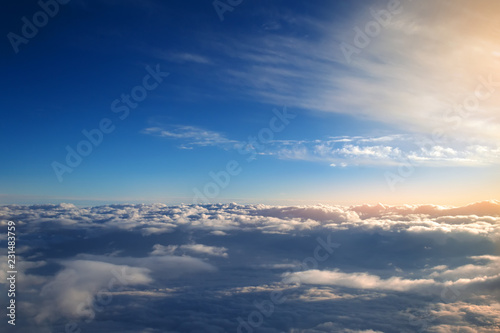 Wall Mural background of blue sky over cumulus clouds with the rays of the setting sun