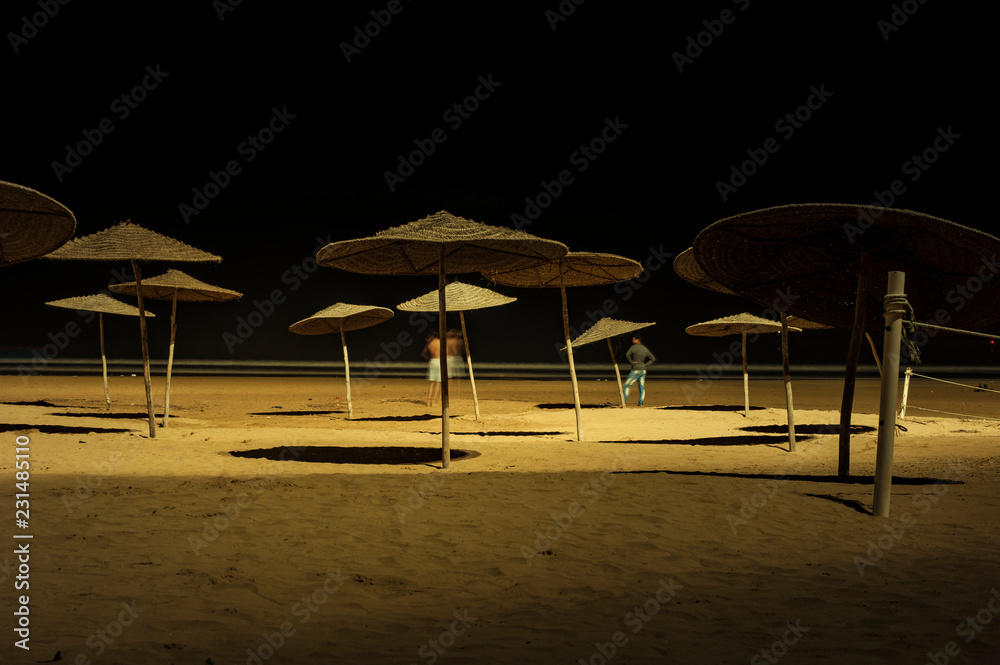 Sunshades on beach at night Essaouira, Morocco