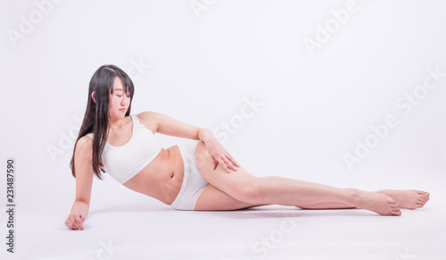 Young woman with perfect body lying down on the white background. Woman with perfect legs