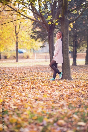 Beautiful young woman posing in park in autumn