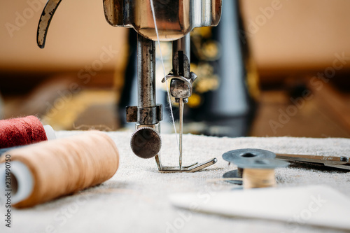 Steel needle with looper and a presser foot of old vintage hand sewing machine close-up