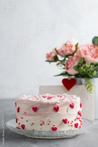Close Up of a cake decorated with small hearts against a gray background. Romantic love concept. Valentine's, Mother's Day, Birthday Cake card Background. © Mila Bond