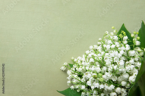 Small Bouquet of Lily of the Valley Flowers with Green Leaves on Beige Vintage Background. Wedding Birthday Mother's Women's Day Greeting Card. Poster Invitation Template
