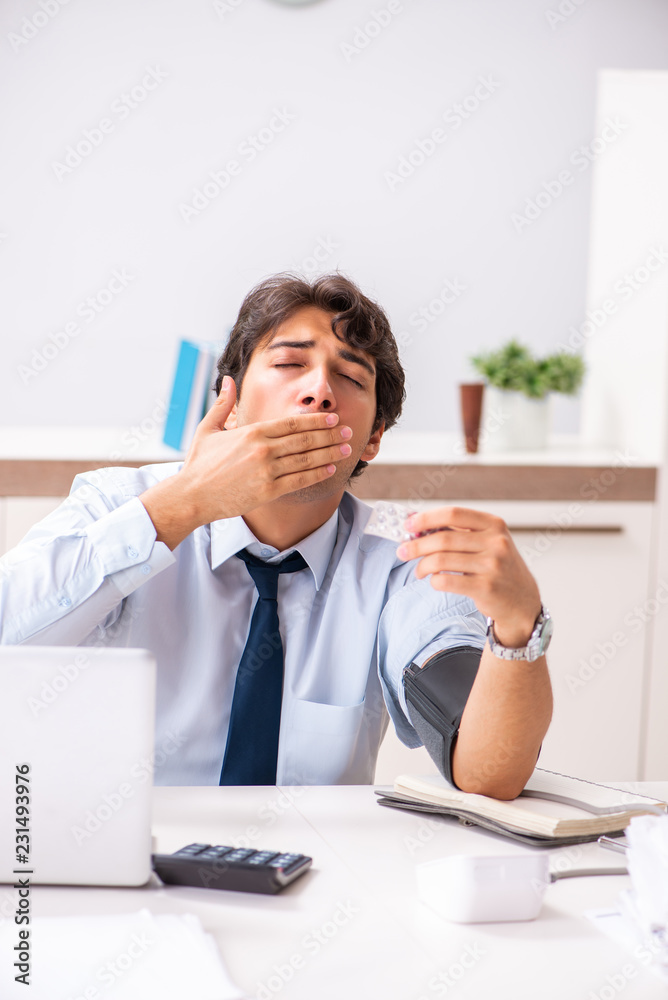 Man under stress measuring his blood pressure Man under stress measuring his blood pressure