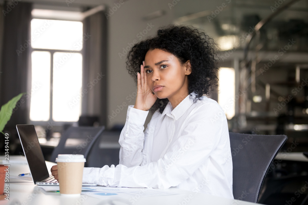 Young black business woman thinking at desk in office Stock Photo