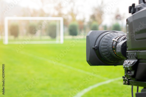 video camera put on the back of football goal for broadcast on TV sport channel. football program can't editing in studio. camera man is importance to catch moment of player. photo