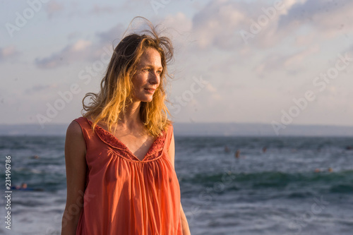oung happy beautiful and glamorous blond woman posing as at the beach wearing stylish dress smiling cheerful feeling fresh and free in beauty fashion concept