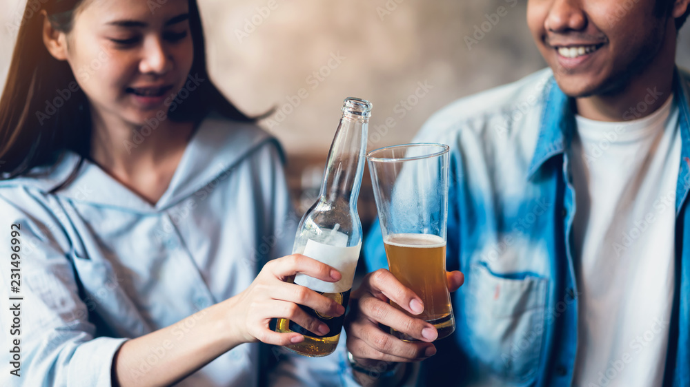 Friends are smiling, happy partying in the bar and talking and clinking bottles with beverages. Friends are smiling, happy partying in the bar and talking and clinking bottles with beverages.