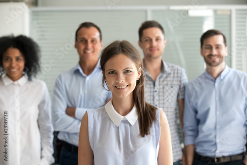 Wallpaper Mural Young female leader, company employee or office worker smiling looking at camera, happy successful millennial professional manager business coach posing with diverse team staff members, portrait Torontodigital.ca