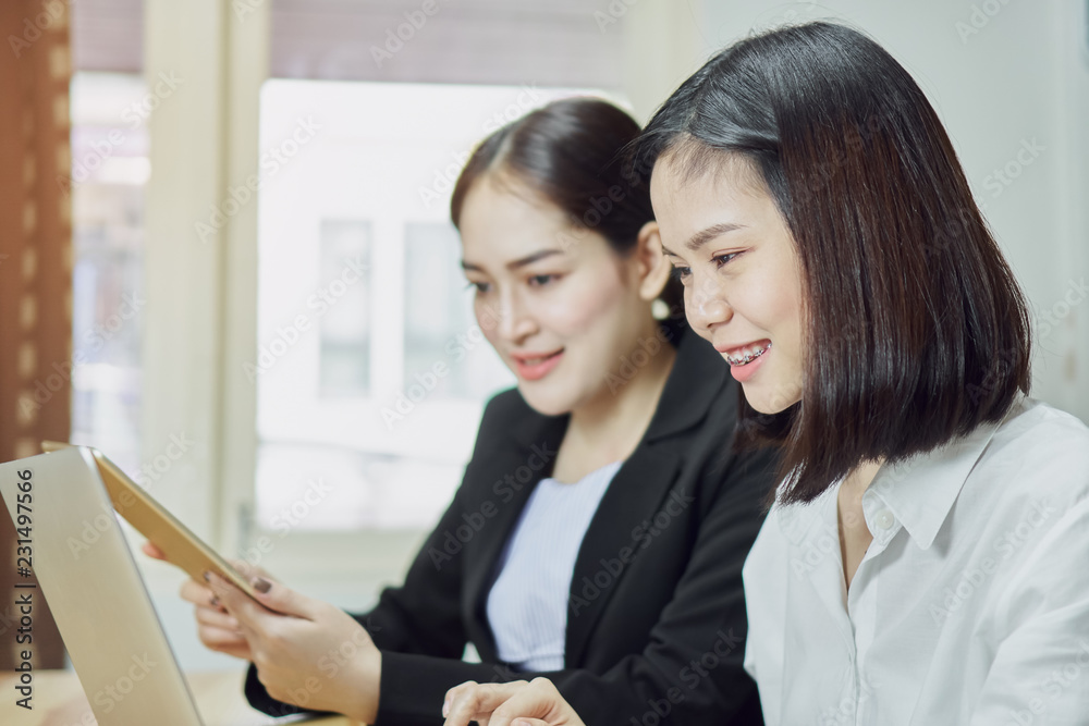 Business women are using laptops and smartphones to work in the office. Customer service outsourcing. Business women are using laptops and smartphones to work in the office. Customer service outsourcing.