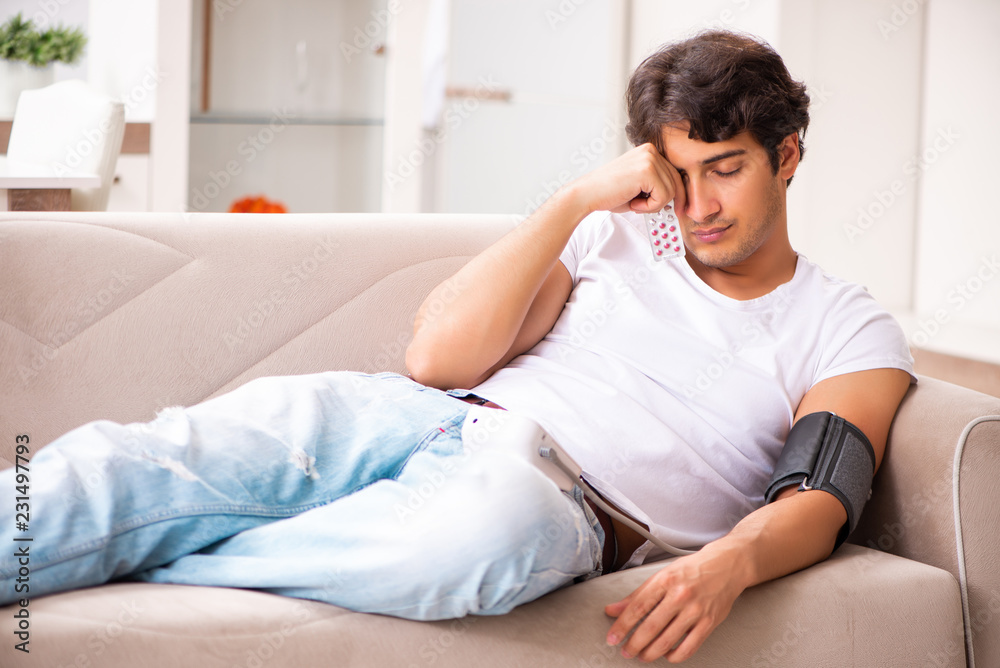 Young man measuring blood pressure at home Young man measuring blood pressure at home
