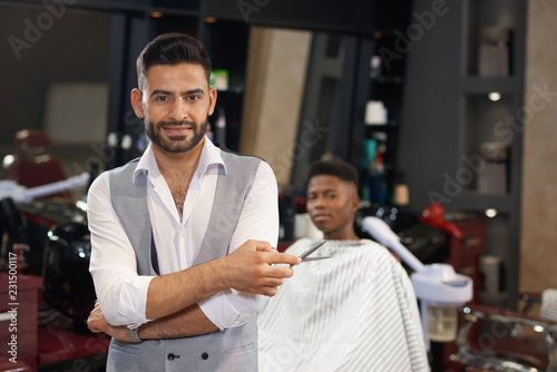 Portrait of stylish barber looking at camera in barber shop