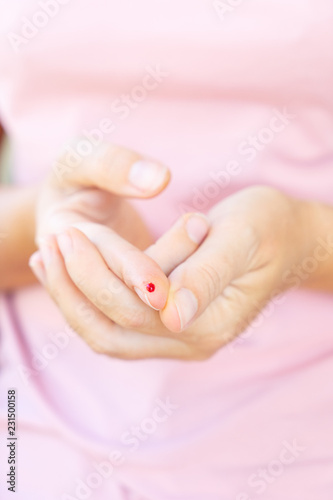 Someones hands with blood drop  measuring blood glucose level