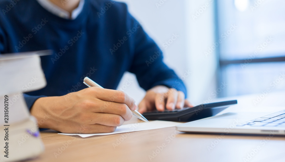 close up on hand writing on paper and press on calculator for computing,working senior man concept. close up on hand writing on paper and press on calculator for computing,working senior man concept.