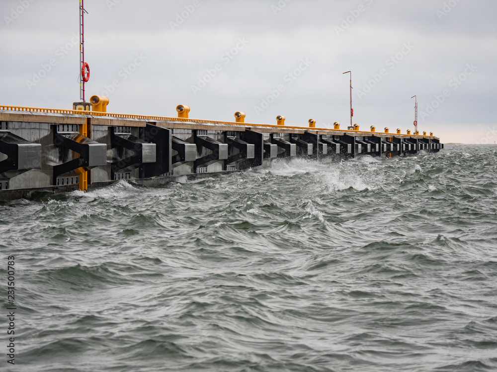 Waves lapping against pier on a windy day