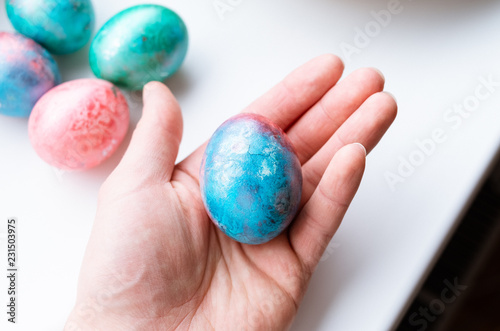 Top view of holding a colourful bright easter egg on a white background.