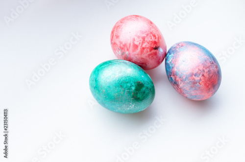 Top view of three colourful easter eggs on a white background.