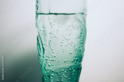 Green blue drinking glass with a cold carbonated mineral water.
