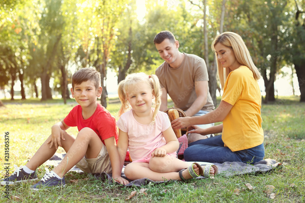 Happy family having picnic in park on sunny day Happy family having picnic in park on sunny day