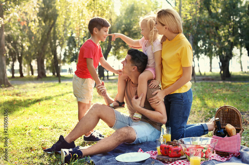 Happy family having picnic in park on sunny day