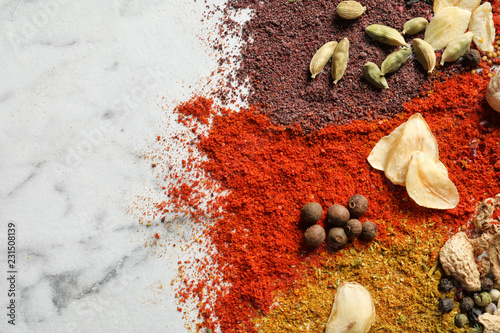 Fototapeta Naklejka Na Ścianę i Meble -  Different aromatic spices on marble background, top view with space for text