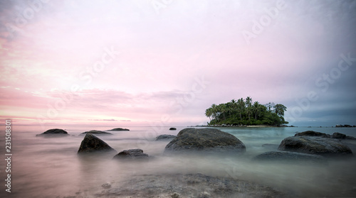 Amazing sunset behind a small island seen from Naiyang beach in Phuket, Thailand