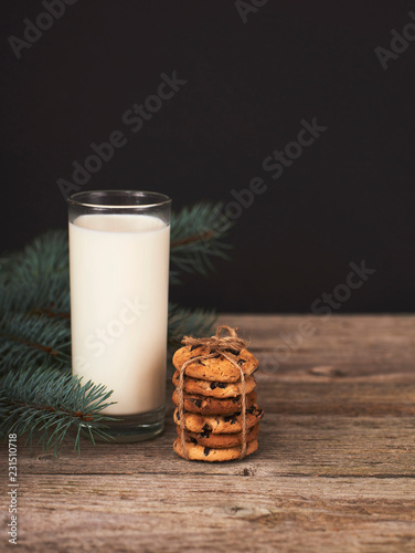 chocolate cookies for Santa and glass of milk on wood board photo