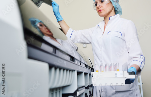 a female scientist near the analyzer in a medical microbiological laboratory. Equipment for analysis, DNA, PCR photo